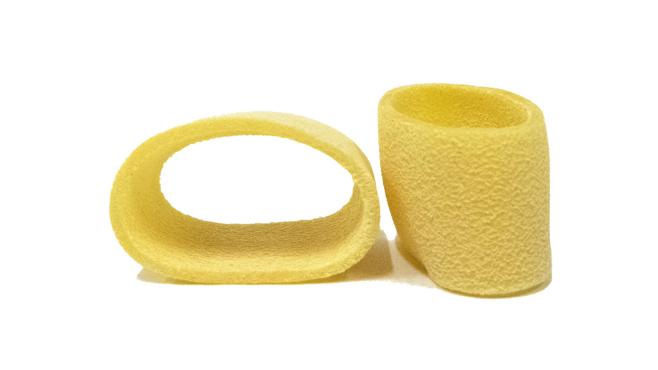 Zwei Calamarata – eine liegend und eine stehend, traditionell handwerklich hergestellte sizilianische Ringnudeln aus Bronzeformen.