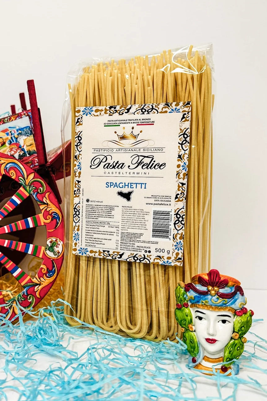 Traditionelle sizilianische Spaghetti Pasta Artigianale neben einem carretto sicilano und einem Testa di Moro – ein Ausdruck sizilianischer Kultur, Handwerk und Genuss.
