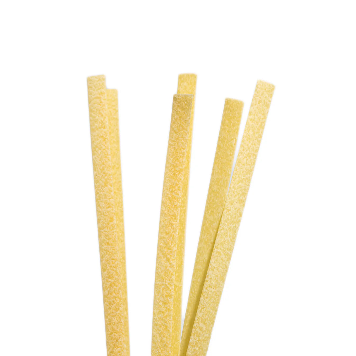 Einzelne Tagliatelle Pasta Artigianale aus 100 % sizilianischem Hartweizen – aufrecht präsentiert mit typischer handwerklicher Struktur.